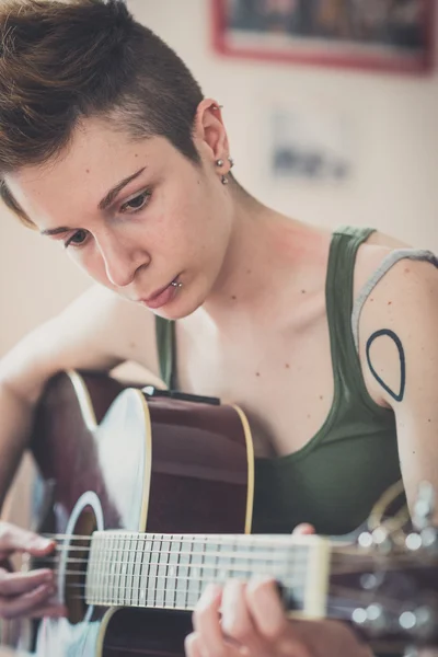 Joven lesbiana elegante pelo estilo mujer jugando guitarra —  Fotos de Stock