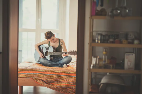 Kobieta młodych lesbijek włosy stylowe styl gry na gitarze — Zdjęcie stockowe