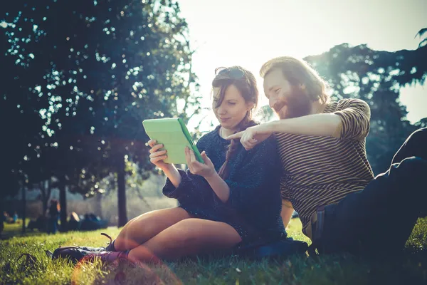 Jovem casal elegante moderno usando tablet urbano — Fotografia de Stock