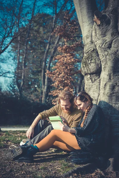 Jovem casal elegante moderno usando tablet urbano — Fotografia de Stock