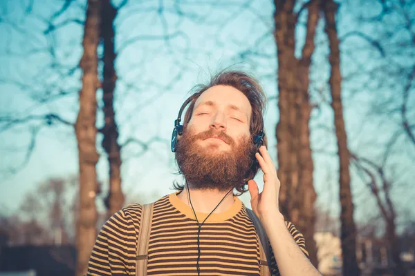 Młody przystojny stylowy mężczyzna słuchania muzyki brodaty — Zdjęcie stockowe