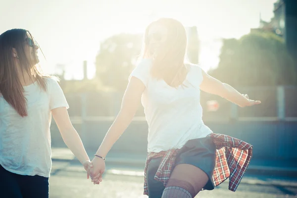 Dos hermosas mujeres jóvenes saltando y bailando —  Fotos de Stock