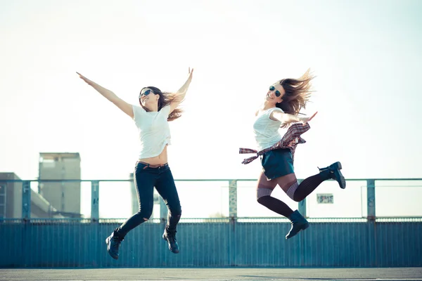Zwei schöne junge Frauen springen und tanzen — Stockfoto