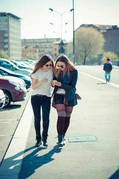 Две красивые молодые женщины с помощью смартфона — стоковое фото