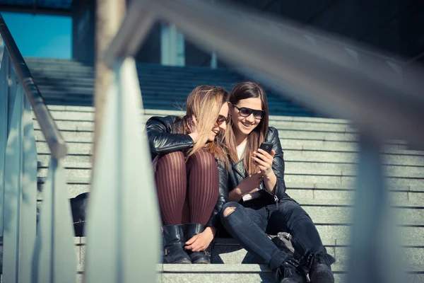 스마트 휴대 전화를 사용 하 여 두 명의 아름 다운 젊은 여성 — 스톡 사진