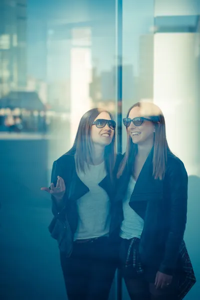Две красивые молодые женщины через стекло — стоковое фото