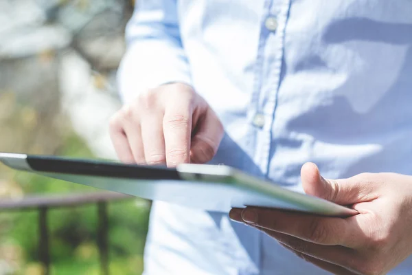 Zblízka do rukou multitasking muže pomocí tabletu — Stock fotografie