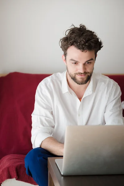 Красивий хіпстер сучасний чоловік працює вдома за допомогою ноутбука — стокове фото