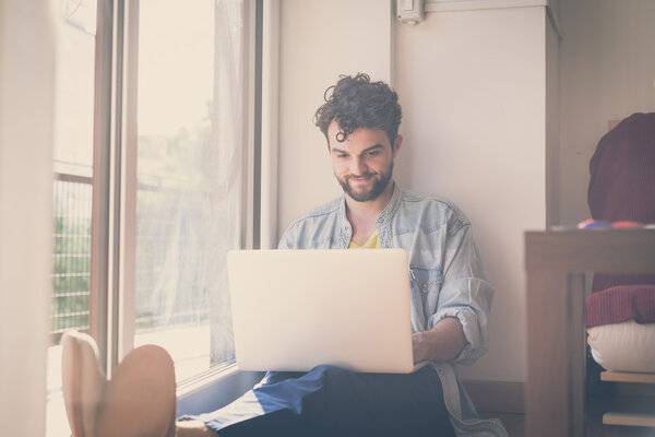 handsome hipster modern man working home using laptop