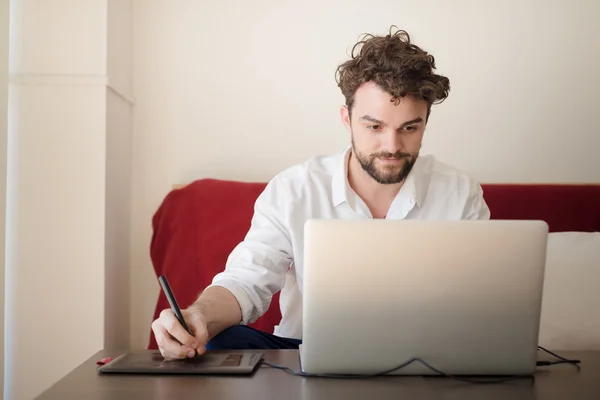 Bonito hipster moderno homem trabalhando em casa usando laptop — Fotografia de Stock