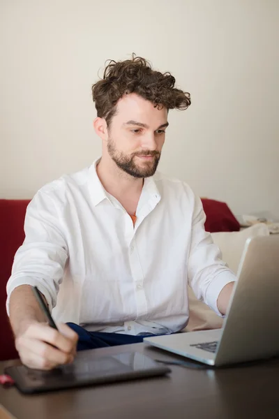 Schöner Hipster moderner Mann arbeitet zu Hause mit Laptop — Stockfoto