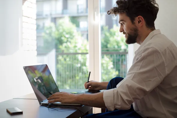 Szép csípő modern ember dolgozik haza használ laptop — Stock Fotó