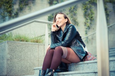 Akıllı telefon kullanan genç ve güzel bir kadın.