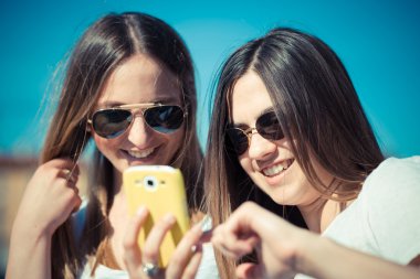 iki güzel genç kadın akıllı telefon kullanma