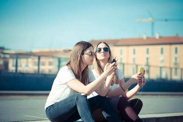 Twee mooie jonge vrouwen met behulp van slimme telefoon — Stockfoto