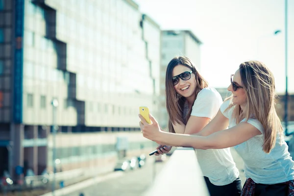 Twee mooie jonge vrouwen met behulp van slimme telefoon — Stockfoto