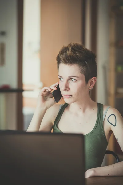 Dizüstü bilgisayar kullanan genç lezbiyen şık saç stili kadın — Stok fotoğraf