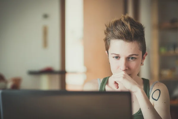 Jeune lesbienne style de cheveux élégant femme à l'aide d'un ordinateur portable — Photo