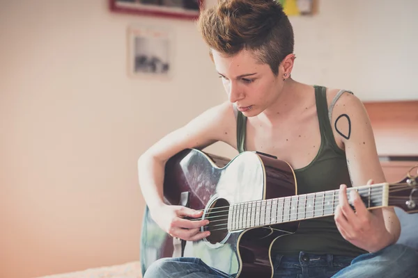 Lesbisk kvinna spela gitarr — Stockfoto