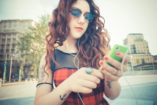 Gekrulde hipster vrouw luisteren muziek — Stockfoto