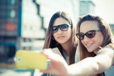 selfie iki güzel genç kadın akıllı kullanarak telefon