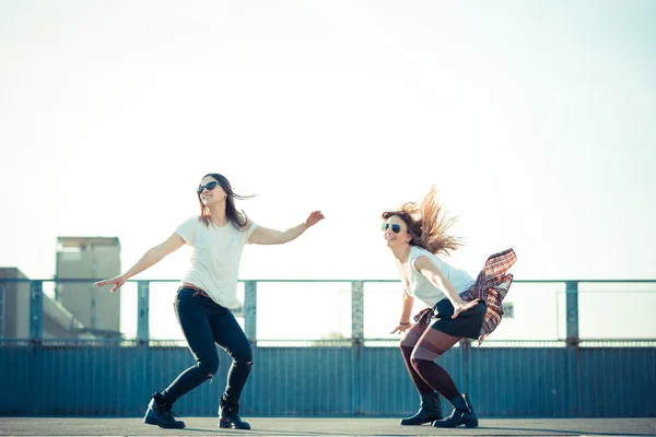 Two beautiful young women jumping and dancing — Stock Photo, Image