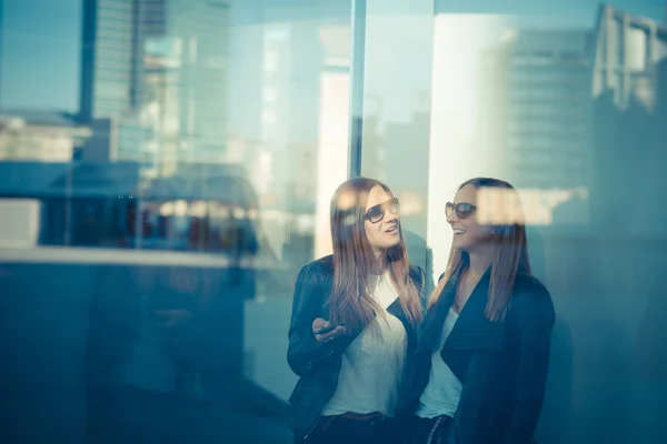 Zwei schöne junge Frauen durch Glas — Stockfoto