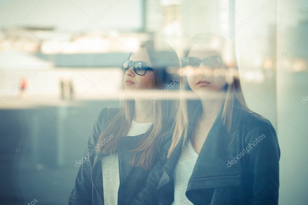 two beautiful young women through glass