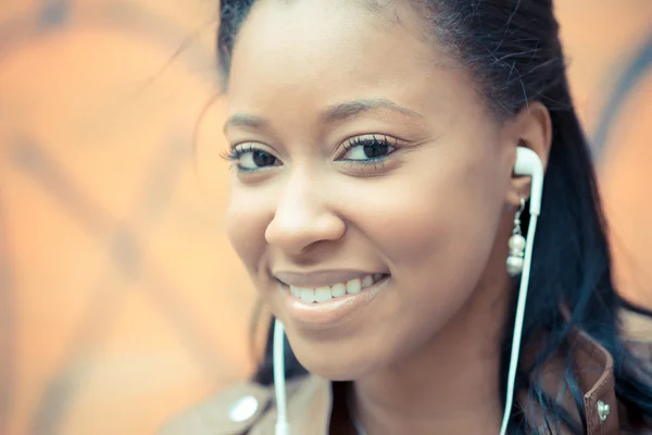 Bella africana giovane donna ascolto musica auricolari — Foto Stock