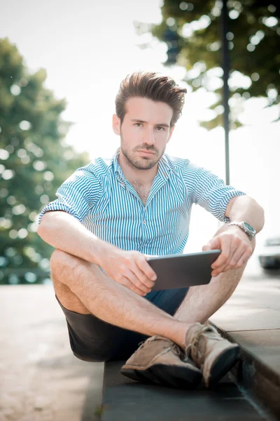 Joven guapo hipster hombre moderno utilizando tableta al aire libre —  Fotos de Stock