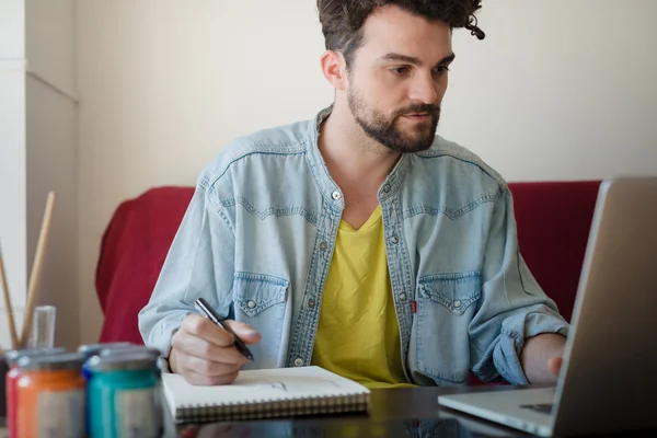 Homme travaillant à la maison en utilisant un ordinateur portable — Photo