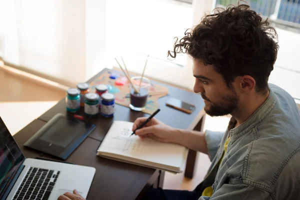 Uomo che lavora a casa con il computer portatile — Foto Stock