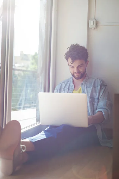 Uomo che lavora a casa con il computer portatile — Foto Stock