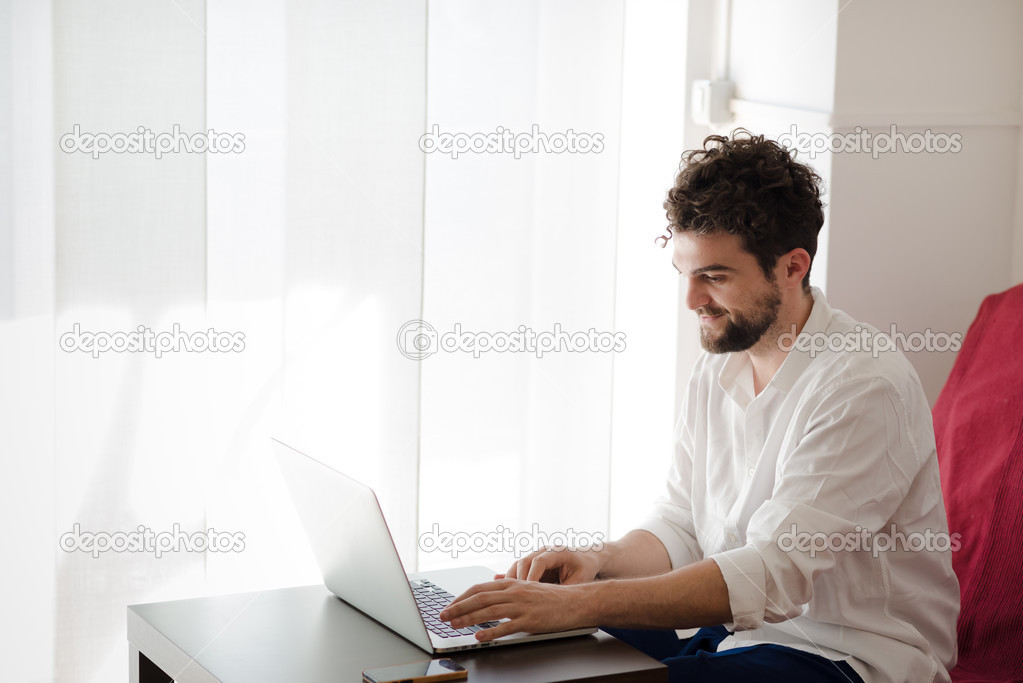 Hipster man working home using laptop