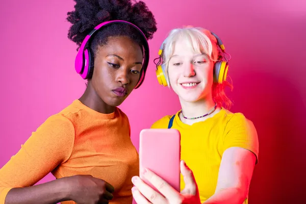 Due Giovani Donne Diverse Migliori Amici Videocalling Utilizzando Smartphone Cuffie — Foto Stock