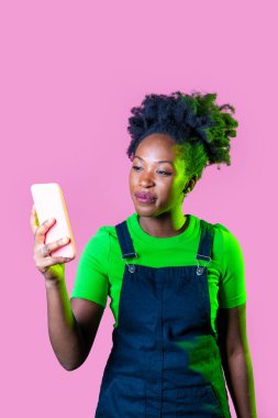 Genç siyahi kadın elinde akıllı telefon tutarak özçekim ağı kuruyor. İnternetten izole edilmiş 5 gramlık internet geçmişi var.