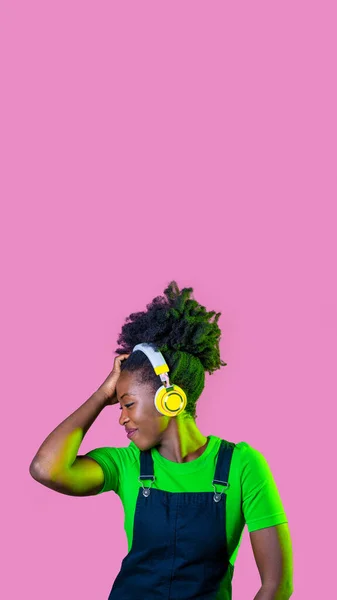 若い巻き毛黒の女性は ワイヤレスヘッドフォン広告コピースペースの背景と音楽を聞いて分離ダンス — ストック写真