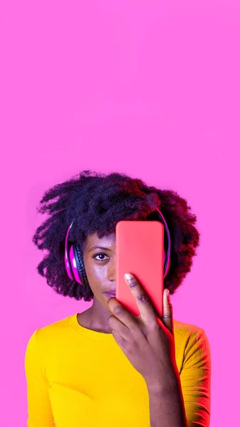 Νεαρή Μαύρη Γυναίκα Που Καλύπτει Πρόσωπό Της Smartphone Φορώντας Ασύρματα — Φωτογραφία Αρχείου