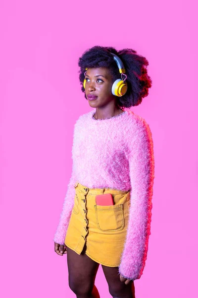 音楽を聴く黒人の若い女性音楽を聴くことを見下ろすワイヤレスヘッドフォン — ストック写真