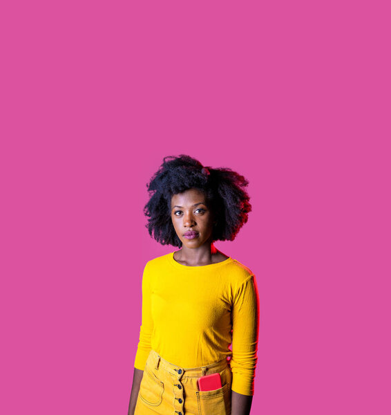 Young black woman posing isolated staring friendly and relaxed on pink advertising copyspace background