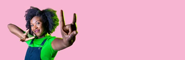 若いです黒の女性隔離されたピンクの広告コピースペースの背景を示す角ジェスチャー — ストック写真