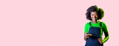 Genç siyahi kadın akıllı telefon sörfü ağı kullanıyor. Gülümsüyor ve mutlu, izole kopya alanı arka planı kullanıyor.