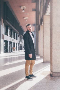 Genç, sakallı, zarif, beyaz bir adam, gülümsüyor, olumlu ve güvenilir bir müşteri.