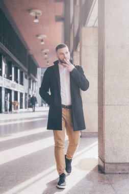 Genç, zarif, başarılı bir iş adamı dışarıda sigara tiryakisi olarak rahatlıyor.