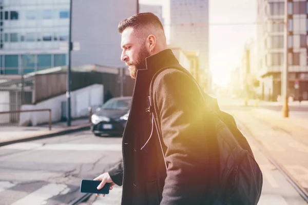 Ung Skäggig Vuxen Man Promenader Utomhus Håller Smartphone Pendling Stad — Stockfoto