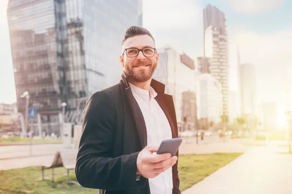 Young Happy Caucasian Bearded Man Outdoor Backlight Using Smartphone Smiling — Stock Photo, Image