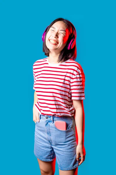 Sereno Asiatica Donna Isolato Sfondo Blu Ascoltare Musica Con Cuffie — Foto Stock
