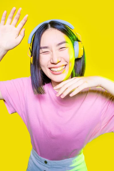 Νεαρή Ασιάτισσα Που Διασκεδάζει Απομονωμένη Κίτρινο Φόντο Ακούγοντας Μουσική Ακουστικά — Φωτογραφία Αρχείου