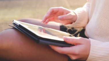 Kadının elini açık havada, tablet sörf internet sitesi ya da alışveriş sitesi kullanarak kapat