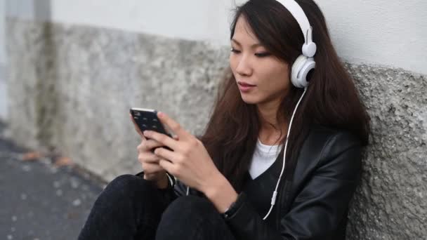 Молодая Азиатская Женщина Слушает Музыку Открытом Воздухе Наушниках Помощью Смартфона — стоковое видео